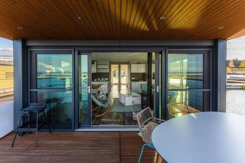 balcón con puertas de cristal, mesa y sillas en Hausboot Paradise, en Klitten