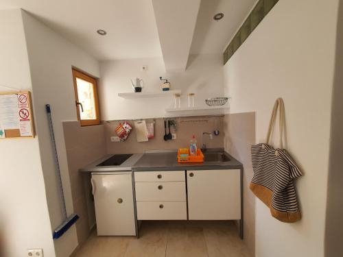 Il comprend une petite cuisine équipée d'un évier et d'une cuisinière. dans l'établissement Maison 2 chambres Olsavinia, à Kaštela