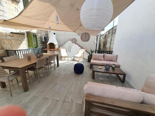 - un salon avec une table, des chaises et un canapé dans l'établissement Maison 2 chambres Olsavinia, à Kaštela