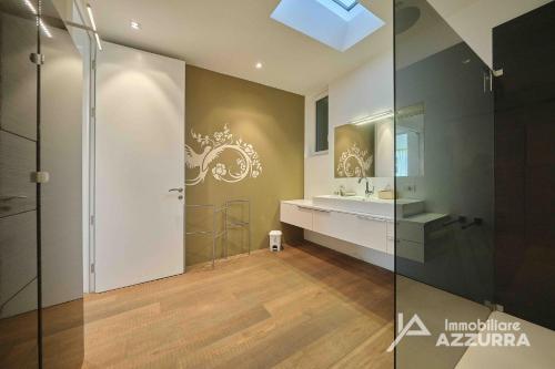 un baño con lavabo y espejo en Villa Madabà - Immobiliare Azzurra, en Bardolino