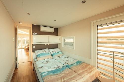 een kleine slaapkamer met een bed in de hoek bij Hausboot Möwenschiss in Klitten