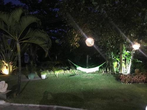 伊波茹卡的住宿－Casa de Praia - Toquinho, Piscina, Área de Laser.，花园中间的吊床(晚上)