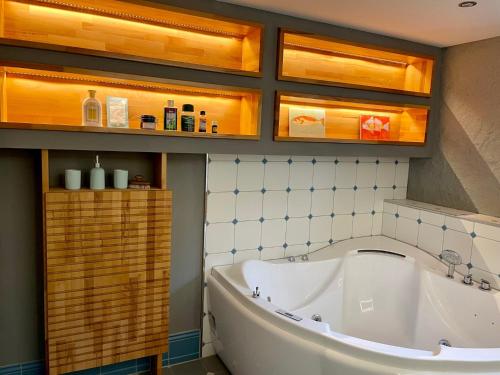 a bath tub in a bathroom with wooden cabinets at Eckhuetteins in Bernried