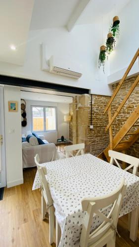 un salon avec une table et une chambre dans l'établissement La casita, entre mer et campagne, à Douvres-la-Délivrande