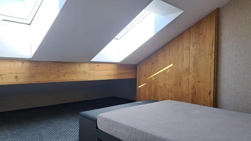 um quarto com uma cama e uma clarabóia em Residence Alpina em Špindlerŭv Mlýn