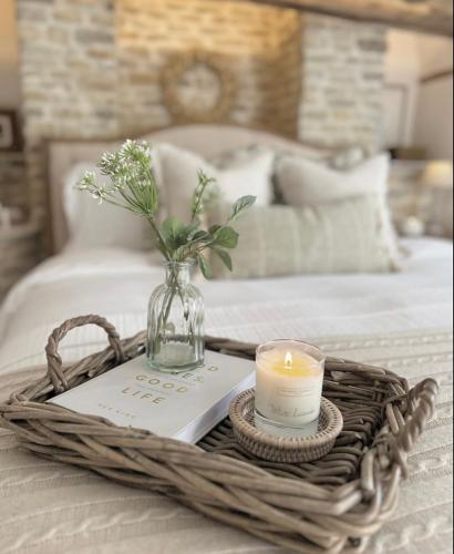 a wicker tray with a candle and a book at Greystone Guesthouse in Titchmarsh