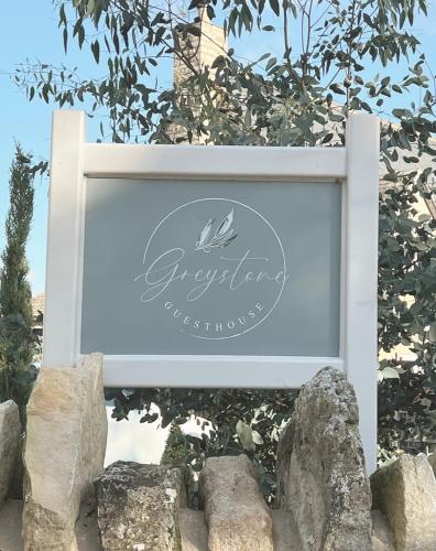 a sign for an outdoor restaurant with rocks at Greystone Guesthouse in Titchmarsh
