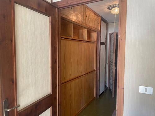 a hallway with a wooden door in a house at Monolocale con terrazzo e vista spettacolare sui monti in Sestriere