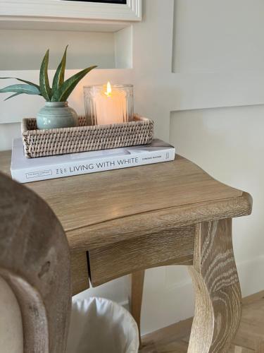 a table with two books and a candle on top at Greystone Guesthouse in Titchmarsh