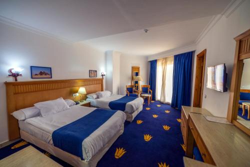una camera d'albergo con due letti e una televisione di Regency Pyramids Hotel a Il Cairo