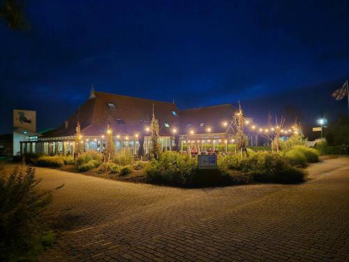 a building lit up at night with lights at Bed and Breakfast De Zeehoeve in Harlingen