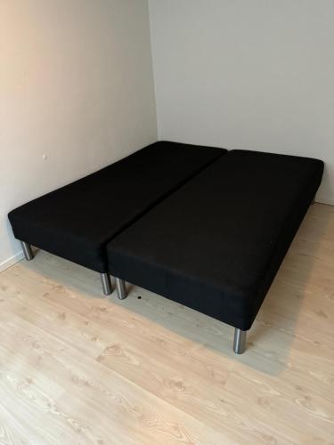 a black bed in a corner of a room at Great View Apartments 3 in Aalborg
