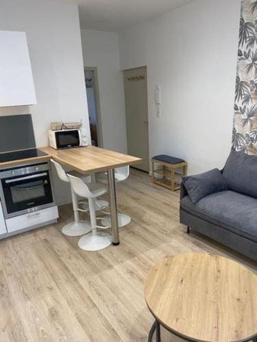 un salon avec une table et un canapé dans l'établissement Agréable T2 en centre-ville, à Vannes