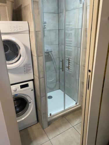 une salle de bains pourvue d'une douche et d'un lave-linge. dans l'établissement Agréable T2 en centre-ville, à Vannes
