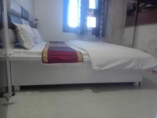 een groot wit bed in een kamer bij Gurjeet Hotel by Naavagat in Amritsar