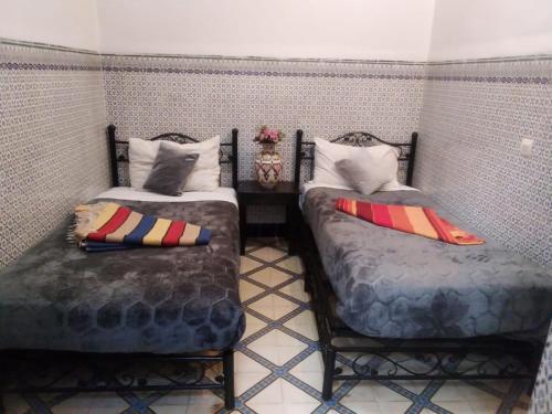 マラケシュにあるHOTEL EL AMALのベッド2台が隣同士に設置された部屋です。