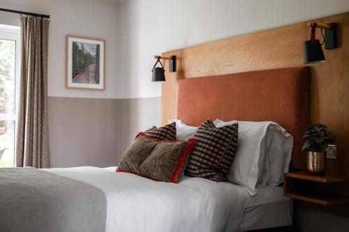 a bedroom with a bed with pillows on it at Worplesdon Place Hotel in Guildford