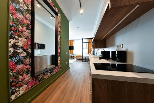 a kitchen with a floral tapestry on the wall at Leda Residence in Oradea