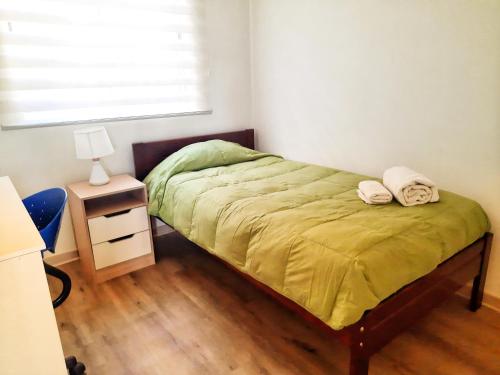 une chambre avec un lit avec deux serviettes dessus dans l'établissement Departamento Centro de Temuco, à Temuco