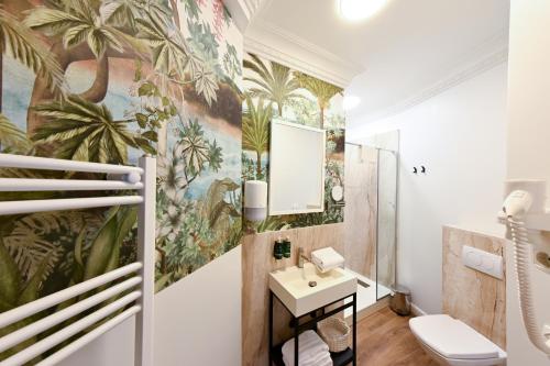 a bathroom with a mural of palm trees on the wall at Leda Residence in Oradea