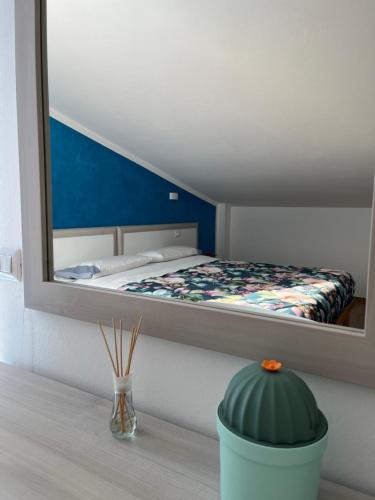 una camera da letto con un letto con uno specchio sul muro di B&b Niu Susu a Lanusei