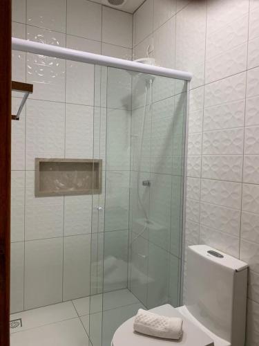 a glass shower in a bathroom with a toilet at Pousada Perola da Praia in Penha
