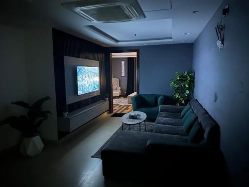 sala de estar con sofá y TV en Executive Presidential suite, en Lahore