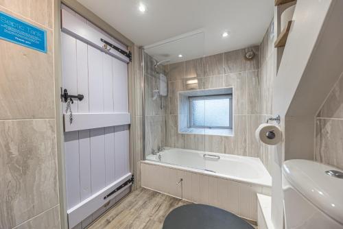a bathroom with a bath tub and a sink at Romantic getaway, little two bed, two bath barn conversion with amazing views and parking in Ambleside