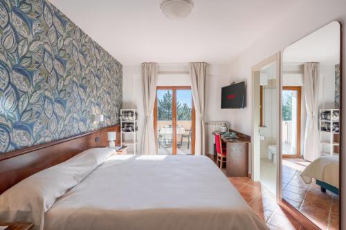 1 dormitorio con 1 cama grande y pared grande en Hotel Rasinus, en Roccaraso