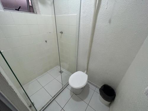 a bathroom with a toilet and a glass shower at Hotel Pax in Ponta Grossa