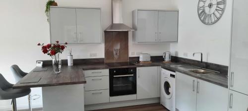 a kitchen with white cabinets and a counter top at Immaculate 1-Bed Apartment in Lanarkshire in Larkhall