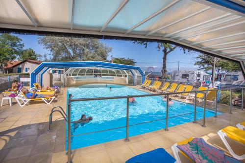 uma grande piscina com pessoas em Mobil Home XXL 4 chambres - Camping Ostrea em Allards