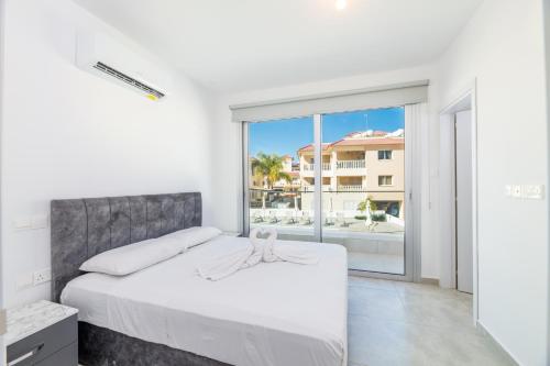 a bedroom with a bed and a large window at PROTARAS HEIGHTS in Protaras