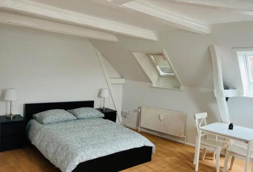 a bedroom with a bed and a table and a desk at Lovely 1 room Apartment Aarhus C in Aarhus