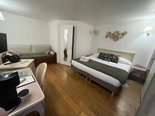 a small bedroom with a bed and a couch at Logis Le Marronnier in Buffon