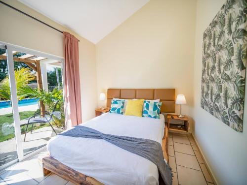 a bedroom with a bed and a large window at Sun Soul - Caribbean 9br Villa In Sosua in Sosúa