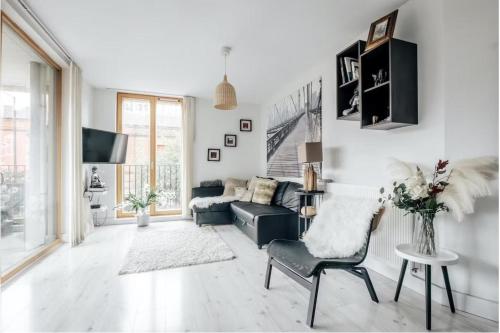 a living room with a couch and a chair at Notting Hill 2-Bed Apt with Balcony 1 min to Tube in London