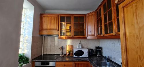 cocina con armarios de madera y encimera en Rooftop Panorama - AC, 4ppl, TV, en Budapest