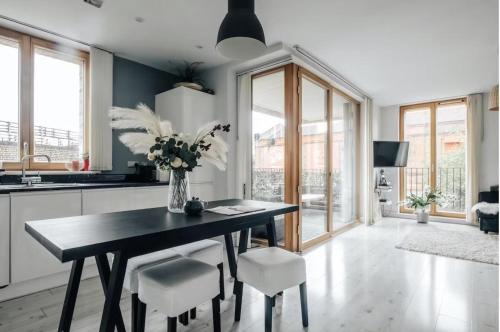 a kitchen with a table with a vase of flowers at Notting Hill 2-Bed Apt with Balcony 1 min to Tube in London