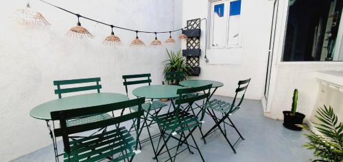 un patio avec deux tables et des chaises avec des plantes dans l'établissement Le Delambre, à Perpignan