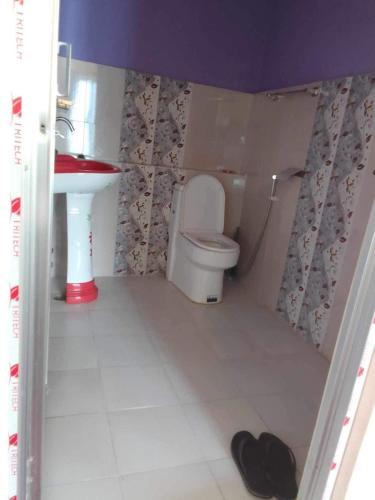 a small bathroom with a toilet and a sink at Fewa View Cottage Yoga Retreat Pokhara in Pokhara