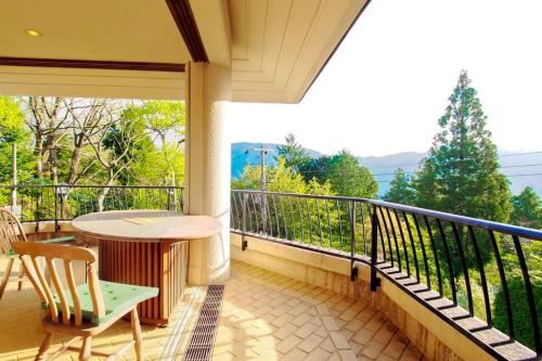 a balcony with a table and chairs and a view at Open-air bath & Private hot-spring Villa in Hakone in Onsensō
