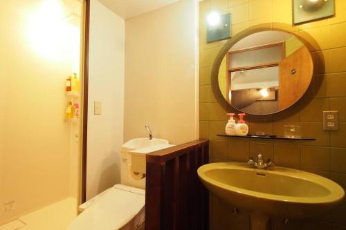 a bathroom with a sink and a mirror and a toilet at Open-air bath & Private hot-spring Villa in Hakone in Onsensō
