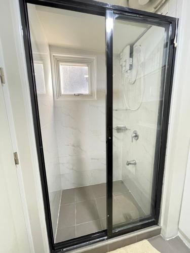 a shower with a glass door in a bathroom at Centrio Tower condominium in Cagayan de Oro