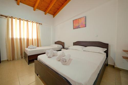a bedroom with two beds with towels on them at Villa Abedini in Ksamil
