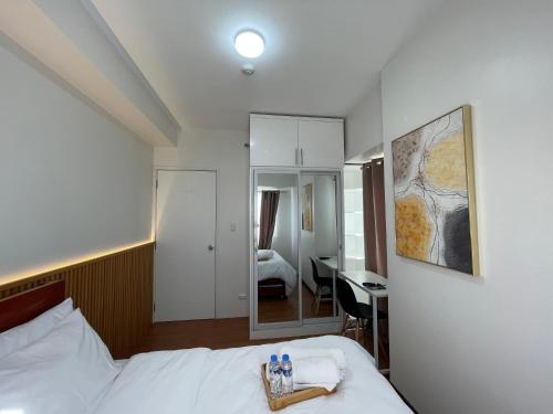 a hotel room with a bed and a mirror at Centrio Tower condominium in Cagayan de Oro