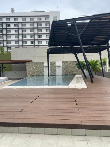 a wooden deck with a black canopy on top of a building at Centrio Tower condominium in Cagayan de Oro