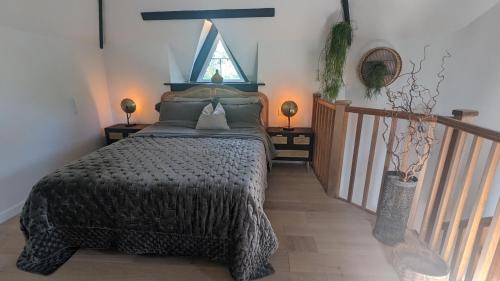 a bedroom with a bed with a window and two lamps at Fairy Cottage in Lea