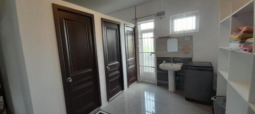uma casa de banho com uma porta preta e um lavatório em Cozy Appartment em Trianon