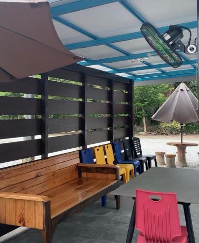 a group of chairs and a table and an umbrella at D' Lembah Pool Homestay Sekinchan in Sekincan